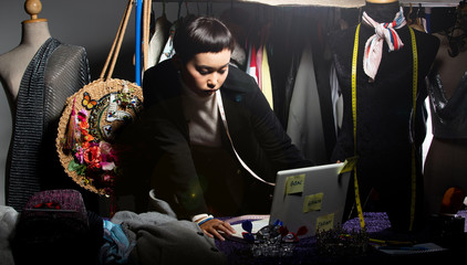 Tomboy Fashion Designer checks order and sale growth on notebook. LBGT Gay tailor styling new trend of dress collection to online store shop and social media, and dartboard as Target Goal Objective