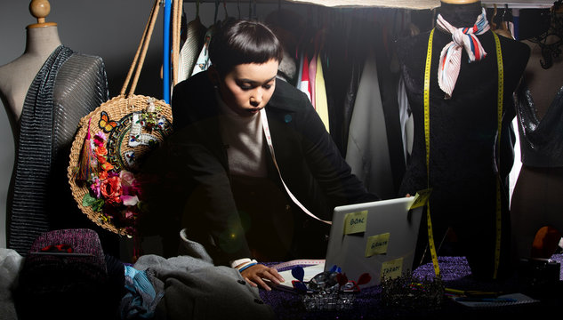 Tomboy Fashion Designer checks order and sale growth on notebook. LBGT Gay tailor styling new trend of dress collection to online store shop and social media, and dartboard as Target Goal Objective