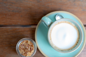 Hot coffee latte  and rock sugar brown on wood table. Top view.