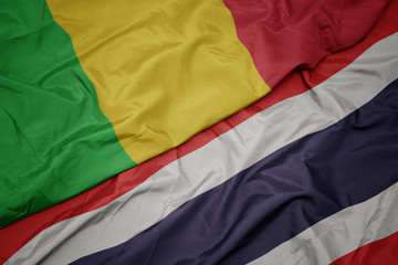 waving colorful flag of thailand and national flag of mali.