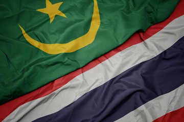 waving colorful flag of thailand and national flag of mauritania.