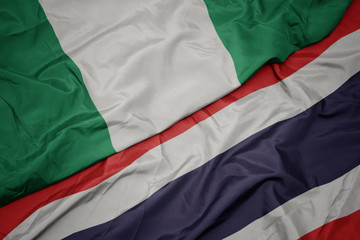 waving colorful flag of thailand and national flag of nigeria.