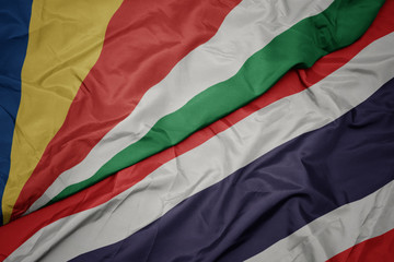 waving colorful flag of thailand and national flag of seychelles.
