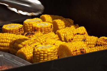 A lot of cooked corn close up. Yellow corn on the table at the festival.