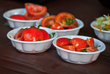Tomato salad on a plate on a wooden table. fresh sliced vegetables.