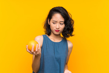 Asian young woman holding an orange