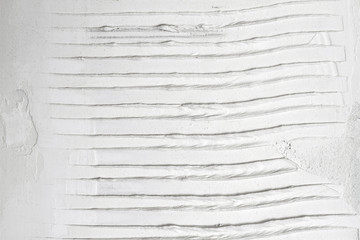 White grooved stucco on wall. Old plaster texture or background. Closeup