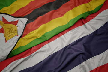 waving colorful flag of thailand and national flag of zimbabwe.