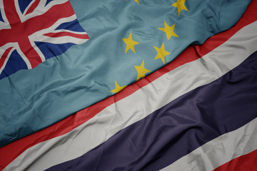 waving colorful flag of thailand and national flag of Tuvalu .