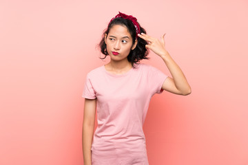 Asian young woman over isolated pink background with problems making suicide gesture