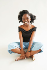 beautiful brunette young dark-skinned woman with shaggy hairstyle smiling cheerfully, showing her white teeth to camera while feeling happy and carefree