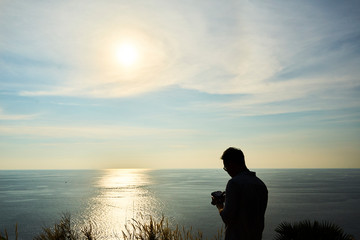 silhouette of man setting camera at sunset