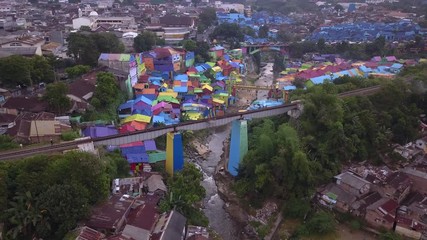 Aerial shot, view high above on the neighborhood and road traffic of Colorful Rainbow villlage at Malang city, Java island, Indonesia 