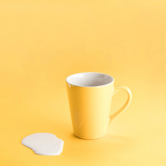 Yellow mug with spilled milk