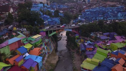 Aerial shot, view high above on the neighborhood and road traffic of Colorful Rainbow villlage at Malang city, Java island, Indonesia 