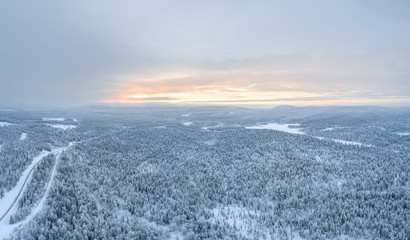 Aerial view of Pyhä-Luosto National Park and vast boreal forest during sunset in winter.