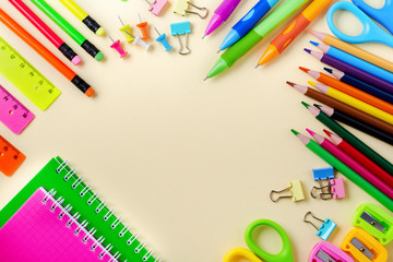 Notebook, colored pencils, ruler, pen, eraser, sharpener and more. School and office stationery on yellow background. Concept back to school. Top view.