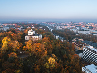 Aerial view of beautiful fall foliage and the Åbo Akademi building on Vartiovuori hill with city center in the background in Turku, Finland