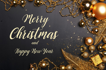 Christmas composition of golden Christmas toys and decoration elements on a black background.