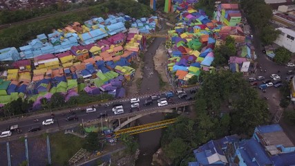 Aerial shot, view high above on the neighborhood and road traffic of Colorful Rainbow villlage at Malang city, Java island, Indonesia 