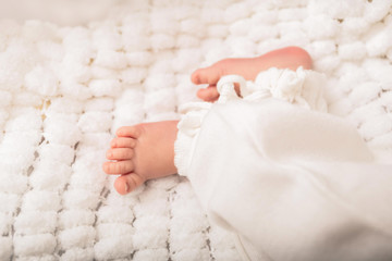 Photo of newborn baby feet on a white cover