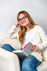 Laughing girl sitting in chair with book in hand