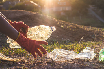 Garbage bottles picked up and thown into a trash bag. Plastic and food waste concept. Clean planet Earth, collect garbage, avoid pollution, save environment.