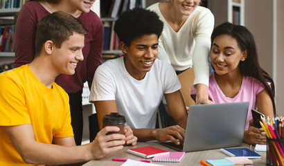Young students checking on test results on laptop