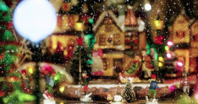 Christmas toy village scene with a ice skaters toys, under the falling snow. Perfect decoration in store, for children in christmas holidays with houses and christmas tree - Christmas & event concept