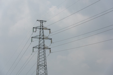 Power transmission tower closeup on blue sky background during daytime