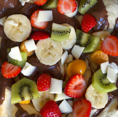 Sweet pizza made of fruits and chocolate spread.