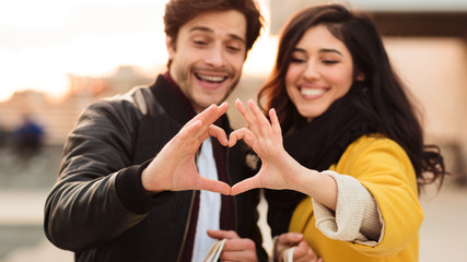 Fototapeta premium Romantic couple making heart shape with hands