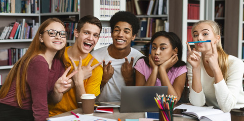 Funny group of students posing at camera in library