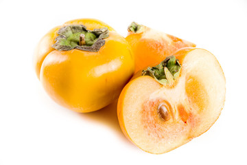Whole and sliced persimmons, fresh organic farm fruit on a white background. Isolated, copy space