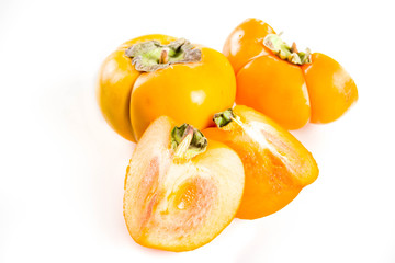 Whole and sliced persimmons, fresh organic farm fruit on a white background. Isolated, copy space
