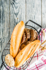 Fresh baked multigrain bread in basket on wooden table. Top view space for text