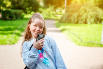 Girl walks on a Sunny summer day with a smartphone