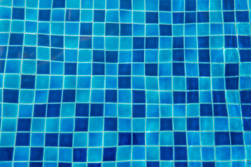 Blue ceramic floor in swimming pool with ripple wave water and sun reflection in background concept