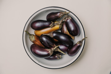 Several ripe eggplant lie in bowl close-up