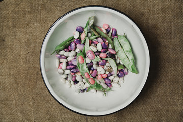 Multi-colored beans lies in white bowl close-up
