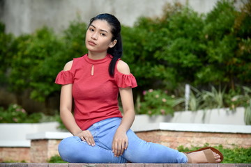 Naklejka premium A Sitting Youthful Asian Girl