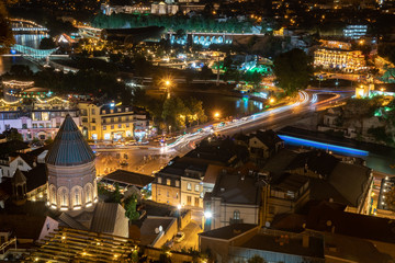 Car lights along Metekhi bridge in Tbilisi, Georgia, at night. Europe square, left bank of Kura river. Travel.