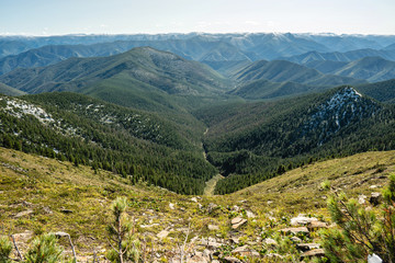 Naklejka premium Beautiful view of the mountains from the peak. Landscape with clouds and stones at sunset. Concept climbing and Hiking