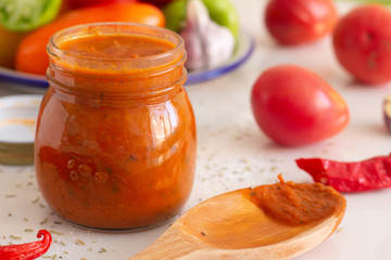 tomato sauce with herbs in a jar and vegetables