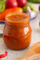 tomato sauce with herbs in a jar close-up