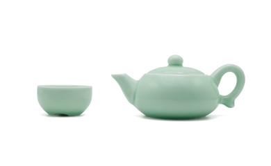 Chinese ceramic green teapot and teacup isolated on white background, side view photo.
