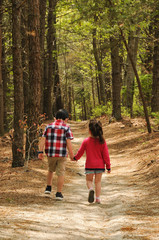 Fototapeta premium brother and sister walking hand in hand on a trail