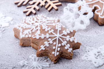 Christmas New Year gingerbread cookies snowflakes on sugar powder background.