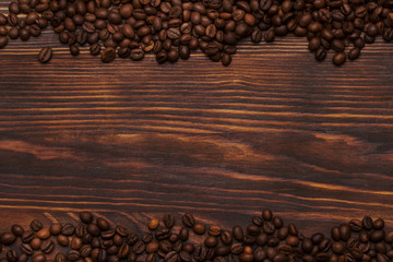 Coffee beans on wooden background with copyspace.