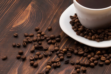 Cup of coffee surrounded by coffee beans.